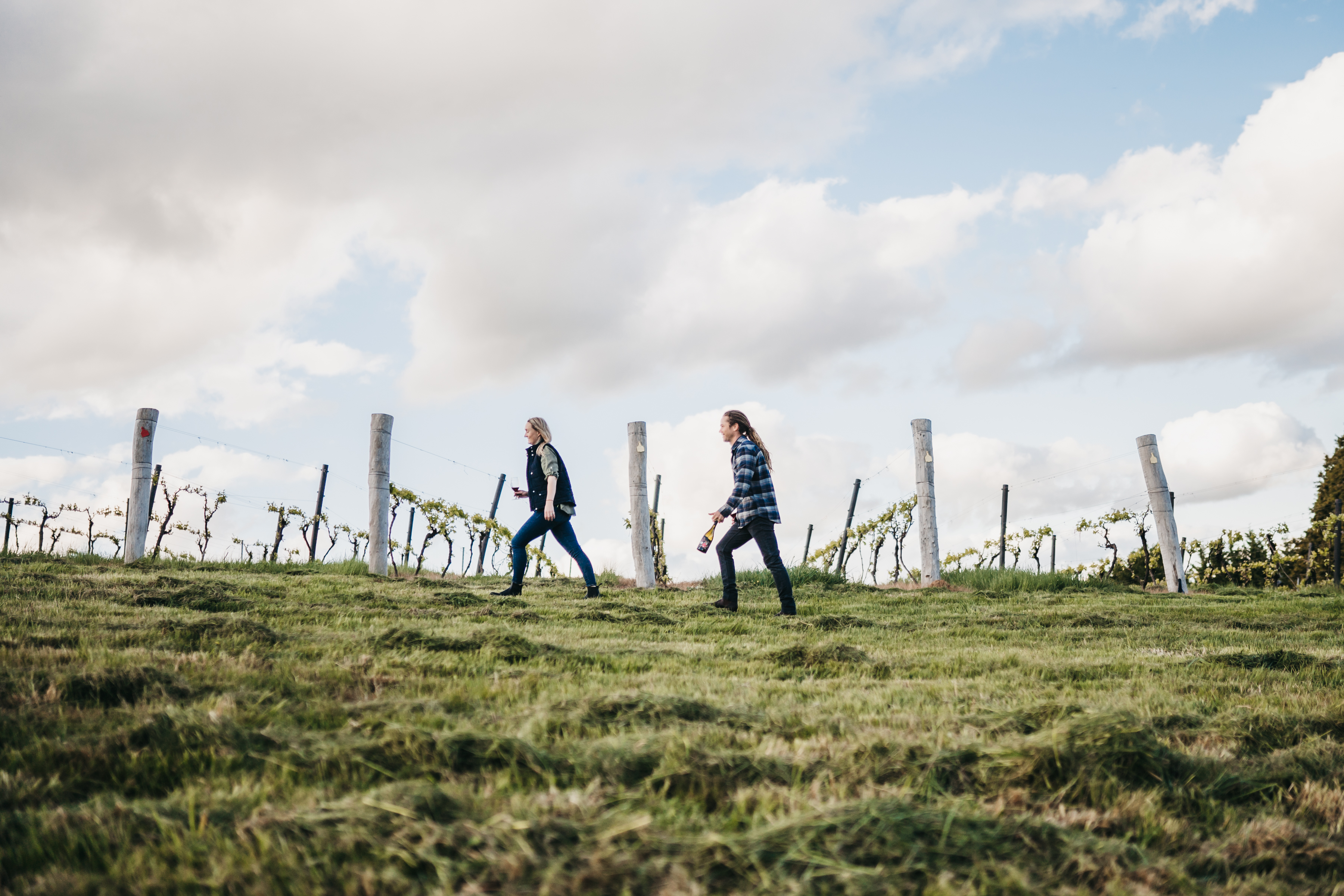 A man and woman walking through the vineyard 